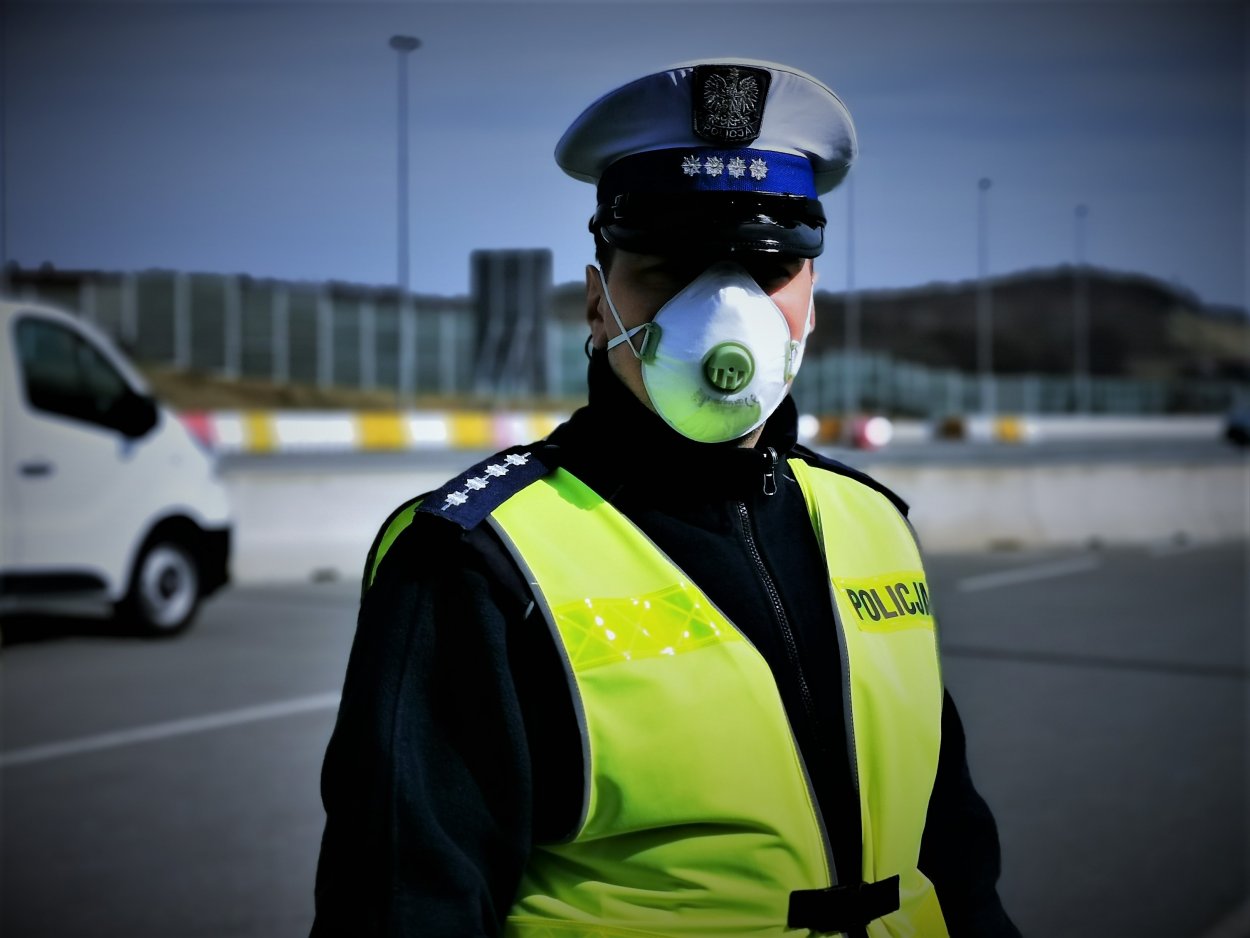 Policjant WRD w maseczce ochronnej stojący na drodze