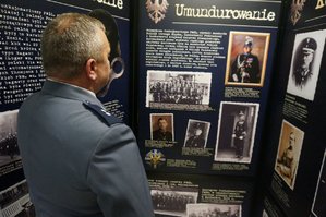 Wykonana 16 kwietnia 2019 r. w katowickim oddziale IPN-u kolorowa fotografia dokumentująca otwarcie wystawy „Zgładzona Formacja. Policja Województwa Śląskiego 1922-1939”, policjant oglądający wystawę.