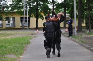 Policjanci oceniani przez sędziego podczas pokonywania toru przeszkód