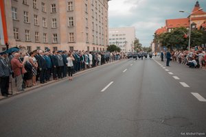 Uczestnicy uroczystości obserwują maszerującą Orkiestrę Komendy Wojewódzkiej Policji w Katowicach podczas musztry na zakończenie części oficjalnej Wojewódzkich Obchodów Święta Policji 219 w Katowicach