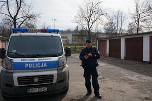 Policjant stojący przy radiowozie