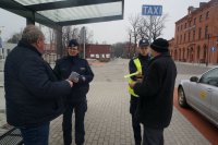 Paski-odblaski dla pieszych i rowerzystów. Dzisiejsze działania pszczyńskich policjantów przy Powiatowym Centrum Przesiadkowym w Pszczynie.Policjanci przekazują odblaski kierowcom taksówek.