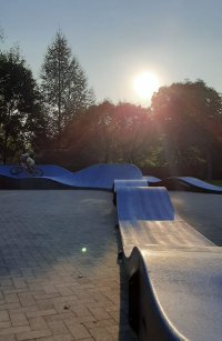 fotografia przedstawia dziecko jadące na rowerze. Dziecko znajduje się na torze przeszkód Pumptracka