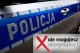 Zdjęcie kolorowe lewych drzwi radiowozu z napisem Policja. Poniżej napis Nie reagujesz-akceptujesz.