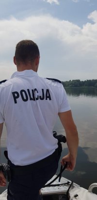 Zdjęcie kolorowe: policjant dbający o bezpieczeństwo nad wodą.