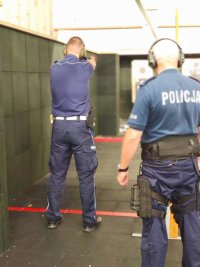 Zdjęcie kolorowe policjant strzela na strzelnicy