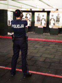 Zdjęcie kolorowe policjantka strzela na strzelnicy