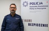 Zdjęcie kolorowe: policjant, w tle baner Komenda Powiatowa Policji w Pszczynie