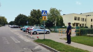 Zdjęcie kolorowe: policjant sprawdza poprawność oznakowania