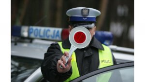 Zdjęcie kolorowe: policjant ruchu drogowego z tarczą