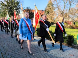 Zdjęcie kolorowe: uczestnicy przemarszu ze sztandarem