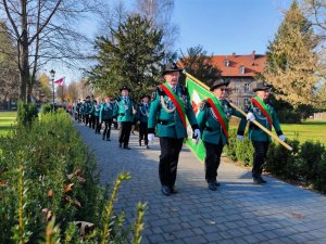 Zdjęcie kolorowe: uczestnicy przemarszu ze sztandarem