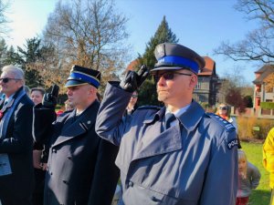 Zdjęcie kolorowe: policjant i funkcjonariusz straży pożarnej salutują