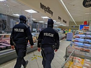 Zdjęcie kolorowe: dwóch umundurowanych policjantów w sklepie