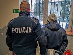 Zdjęcie kolorowe: umundurowany policjant wraz z zatrzymanym mężczyzną