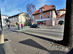 Zdjęcie kolorowe: kobieta znajduje się w połowie przejścia dla pieszych. Widoczny samochód który mimo to przejeżdża.