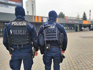 Zdjęcie kolorowe: dwóch umundurowanych policjantów, w tle widoczna kopalnia Pniówek