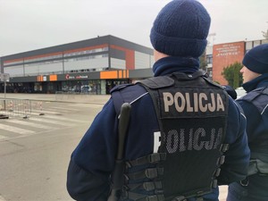 Zdjęcie kolorowe: dwóch umundurowanych policjantów, w tle widoczna kopalnia Pniówek