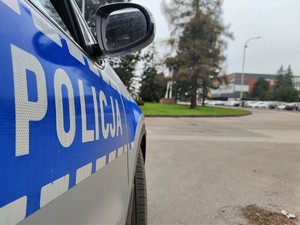 Zdjęcie kolorowe: napis Policja z oznakowanego radiowozu, w tle widoczna kopalnia.