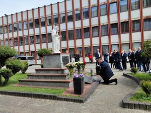 Zdjęcie kolorowe: na pierwszym planie widoczny prezydent, który kleka przed pomnikiem Świętej Barbary