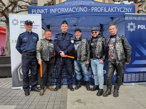 Zdjęcie kolorowe: dwóch umundurowanych policjantów wraz z motocyklistami