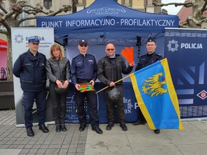 Zdjęcie kolorowe: trzech umundurowanych policjantów, obok kobieta i mężczyzna. W tle widoczny namiot policyjny