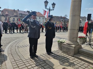 Zdjęcie kolorowe: policjant i strażak pożarny oddają honor