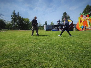 Zdjęcie kolorowe: dwóch mężczyzn naprzeciwko siebie, osoby podczas pokazu sztuk walki.