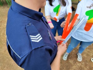 Zdjęcie kolorowe: na pierwszym planie widać policyjne pagony. Mundurowy trzyma w rękach opaki odblaskowe.