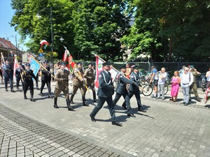 Zdjęcie kolorowe: widoczne poczty sztandarowe podczas przemarszu.