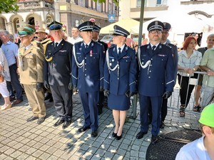 Zdjęcie kolorowe: widoczni umundurowani policjanci wraz z innymi uczestnikami.