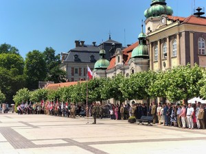 Zdjęcie kolorowe: widoczni uczestnicy uroczystości na płycie rynku w Pszczynie.