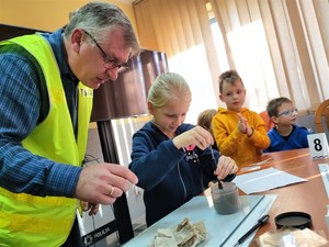 Zdjęcie kolorowe przedstawia dziewczynkę, która będzie zbierała swoje odciski palców.