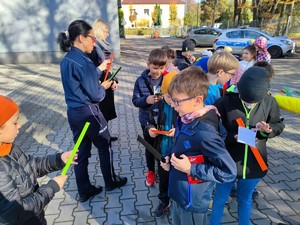 Zdjęcie kolorowe przedstawia policjantkę, która mówi do grupy dzieci.