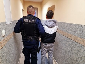 Zdjęcie przedstawia umundurowanego policjanta z zatrzymanym mężczyzną.