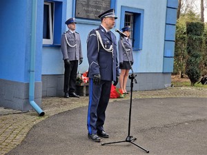 Zdjęcie przedstawia umundurowanego policjanta przed mikrofonem podczas przemówienia.