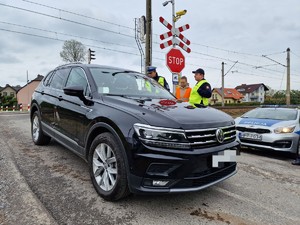 Zdjęcie przedstawia: dwóch mundurowych i kobietę w kamizelce odblaskowej przy samochodzie osobowym.