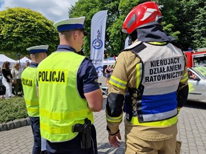 Zdjęcie przedstawia: trzech mężczyzn, dwóch umundurowanych policjantów oraz strażaka