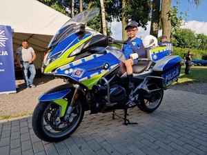 Zdjęcie przedstawia: chłopca na policyjnym motocyklu.