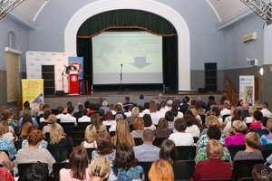 Zdjęcie przedstawia: salę konferencyjną wypełnioną słuchaczami, przy mównicy mężczyzna.