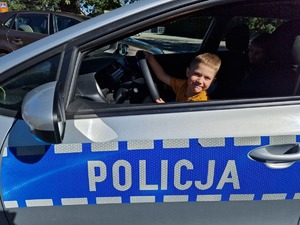 Zdjęcie przedstawia: dziecko w policyjnym radiowozie.