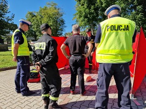 Zdjęcie przedstawia: policjantów, strażaków i mężczyznę podczas ćwiczeń przy fantomie.