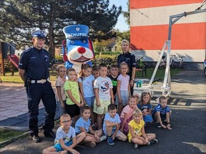 Zdjęcie przedstawia grupę dzieci i dwoje policjantów.