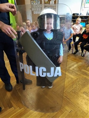 Zdjęcie przedstawia: przedszkolaka z policyjną tarczą.