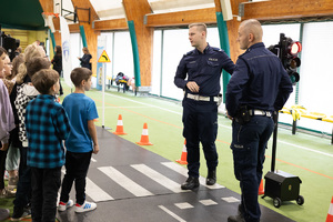 Zdjęcie przedstawia: umundurowanych policjantów podczas rozmowy z grupą dzieci.