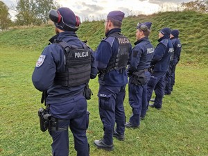 Zdjęcie przedstawia: umundurowanych policjantów stojących w szeregu podczas prezentacji na strzelnicy.