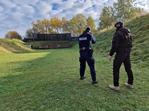 Zdjęcie przedstawia: policjanta podczas ćwiczeń. Obok widoczny instruktor.