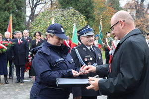 Zdjęcie przedstawia: umundurowaną policjantkę podczas odbierania wyróżnienia.