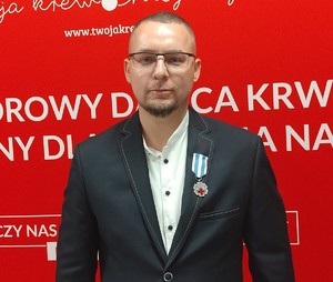 Zdjęcie przedstawia: mężczyznę z odznaczeniem.