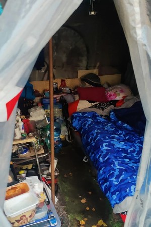 Zdjęcie przedstawia: wnętrze namiotu, w którym mieszka osoba bezdomna.